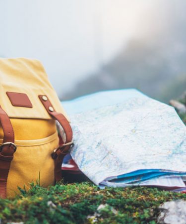 Photo d'un sac à dos et un carte de voyage avec vue sur la montagne