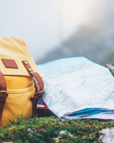 Photo d'un sac à dos et un carte de voyage avec vue sur la montagne